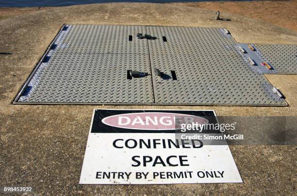 danger: confined space. entry by permit only sign on the water pumping station at gallipoli reach, canberra, australian capital territory, australia - afgesloten ruimte stockfoto's en -beelden