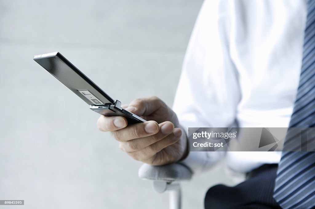 Businessman using mobile phone,close up