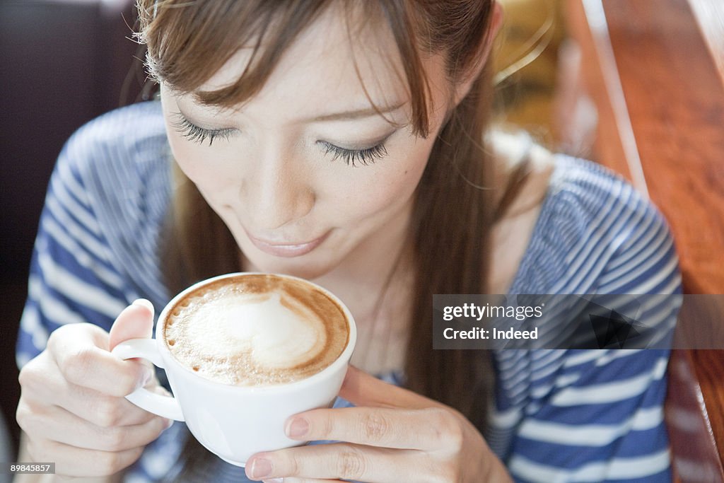 Young woman drinking cappccino, high angle view