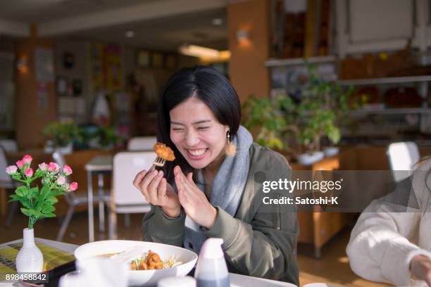 happy woman eating fried chicken for lunch - japanese restaurant stock pictures, royalty-free photos & images