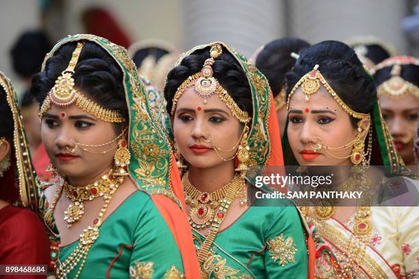 This picture taken on December 24, 2017 shows Indian brides prepare for a mass wedding ceremony in Surat, some 270km from Ahmedabad. 251 fatherless...