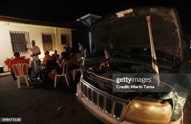 Car battery connected to an inverter provides power for a makeshift street party, on a block without grid electricity, on Christmas Eve on December...