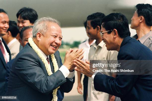 Prince Norodom Sihanouk of Cambodia is welcomed by Prime Minister Hun Sen on arrival at Pochentong International Airport on July 7, 1992 in Phnom...