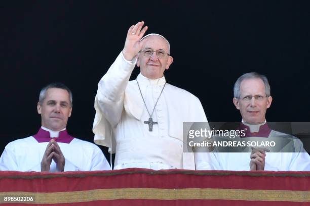 Pope Francis waves from the balcony of St Peter's basilica during the traditional "Urbi et Orbi" Christmas address and blessing given to the city of...