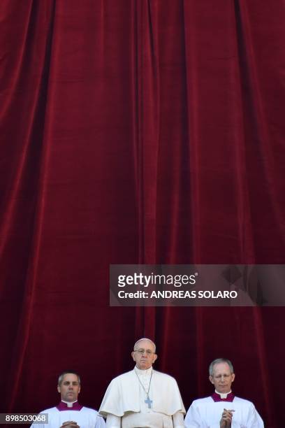 Pope Francis stands from the balcony of St Peter's basilica during the traditional "Urbi et Orbi" Christmas address and blessing given to the city of...
