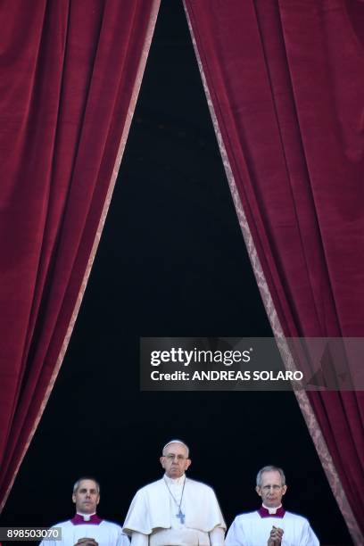 Pope Francis stands from the balcony of St Peter's basilica during the traditional "Urbi et Orbi" Christmas address and blessing given to the city of...