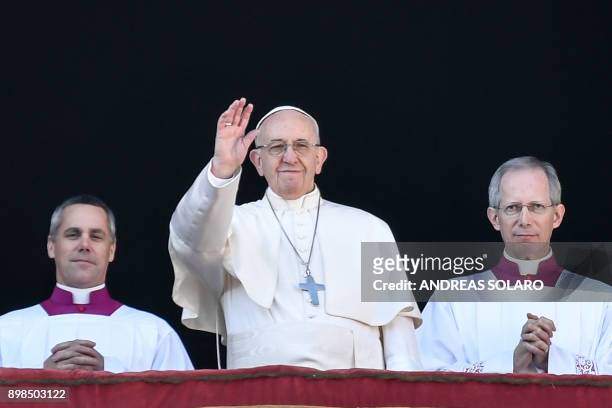 Pope Francis waves from the balcony of St Peter's basilica during the traditional "Urbi et Orbi" Christmas address and blessing given to the city of...