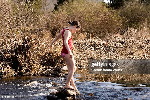 young girl in dipping toe in a stream. - dip toe stock pictures, royalty-free photos & images