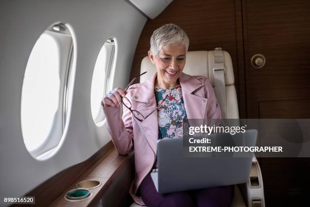 woman in private jet airplane - extreme wealth stock pictures, royalty-free photos & images