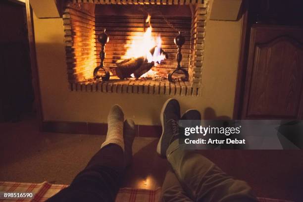 romantic date of a couple in love in the countryside with old house and fireplace during winter in the catalan pyrenees spending the christmas time vacations. - haardvuur stockfoto's en -beelden