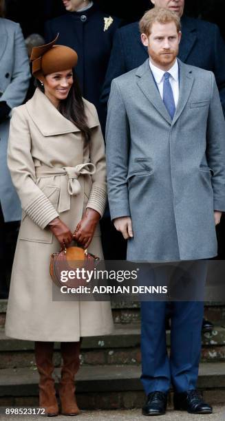 Actress and fiancee of Britain's Prince Harry Meghan Markle and Britain's Prince Harry stand together as they wait to see off Britain's Queen...