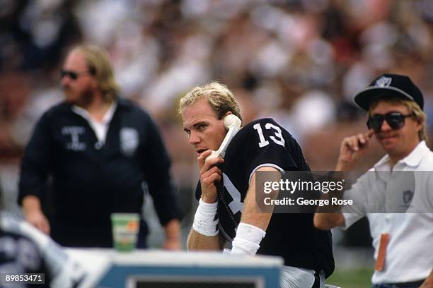 Quarterback Jay Schroeder of the Los Angeles Raiders talks on the phone during the game against the Green Bay Packers at the Los Angeles Memorial...