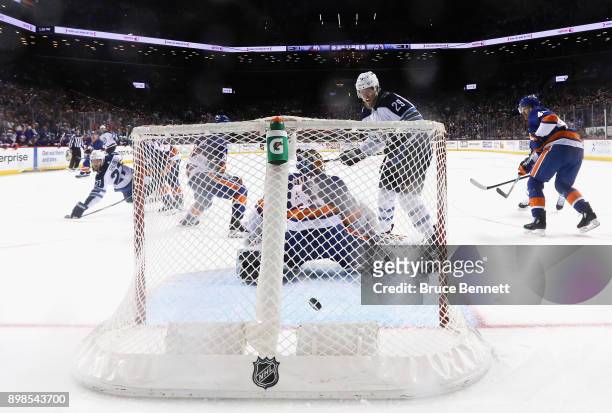 Patrik Laine of the Winnipeg Jets watches the first NHL goal go into the net for Tucker Poolman of the Winnipeg Jets against the New York Islanders...