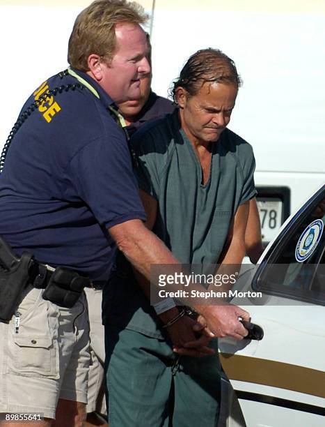 Mark McLeod of Appling, Ga. Is escorted to a car by police following a court hearing at the Tybee Island Municipal Court on August 18, 2009 in Tybee...