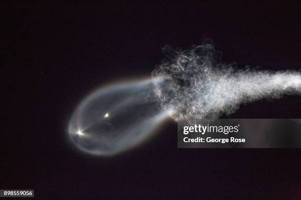 The contrail from a SpaceX Falcon 9 rocket launched at Vandenberg Air Force Base lights up the early evening sky on December 22 as viewed from...
