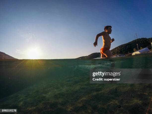 bambini che nuotano nel mare - half underwater foto e immagini stock