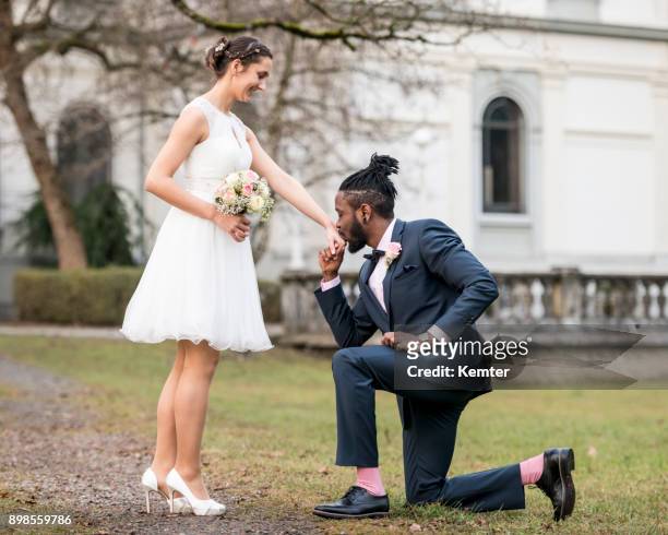 gentle groom kneeling in front of the bride - kissing hand stock pictures, royalty-free photos & images