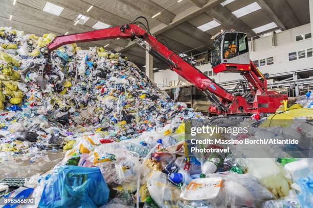 mechanical grabber at work in a recycling center - centro di riciclaggio foto e immagini stock