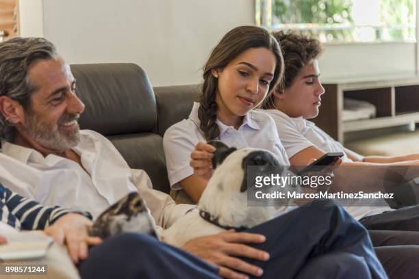 dog sitting quietly with family at leisure time in the living room - lypsesp17 stock pictures, royalty-free photos & images