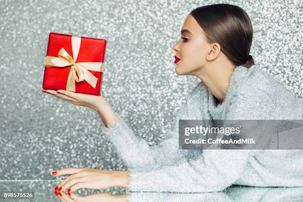 jonge vrouw met de doos van de gift in haar handen - christmas beauty stockfoto's en -beelden