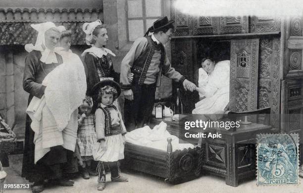 Around the closed bed : departure for the christening, postcard, c. 1903