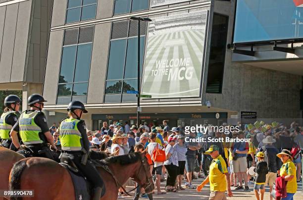 Police officers wait on horses as patrons queue to enter the ground during day one of the Fourth Test Match in the 2017/18 Ashes series between...