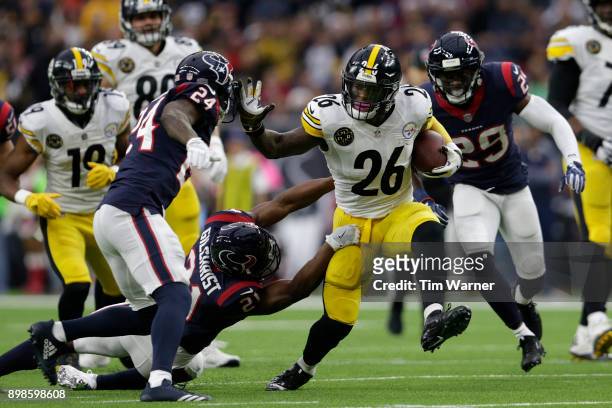 Le'Veon Bell of the Pittsburgh Steelers gives a stiff arm to Johnathan Joseph of the Houston Texans in the first quarter at NRG Stadium on December...