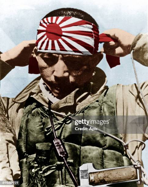 Japanese kamikaze putting on his forehead bandeau with rising sun, Pacific war, 1944-1945 colorized document