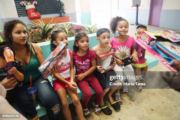 Children who currently reside in a shelter for Hurricane Maria victims wait to receive Christmas presents donated by a local church on December 25,...