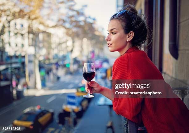 chica joven busca la ciudad en el balcón y beber vino tinto - bistro paris fotografías e imágenes de stock