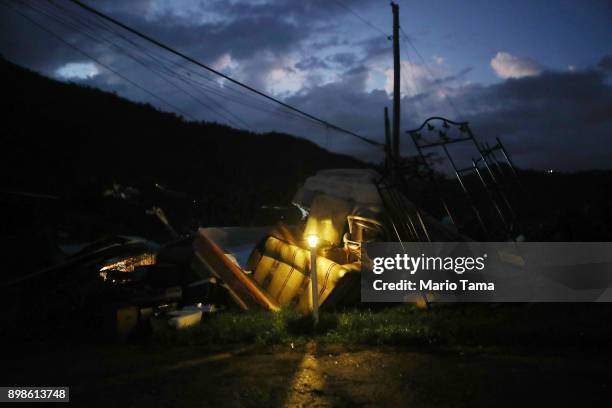 Donated solar lamp in a driveway illuminates storm debris still waiting to be collected on Christmas day on December 25, 2017 in Morovis, Puerto...