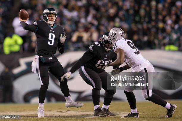 Nick Foles of the Philadelphia Eagles passes the ball as Chance Warmack blocks Shilique Calhoun of the Oakland Raiders in the second quarter at...