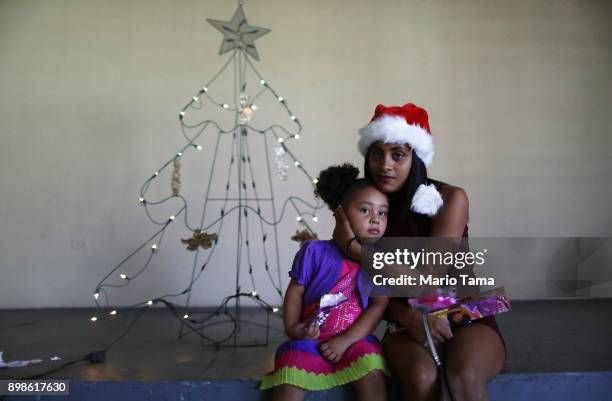 Cindy Vazquez Cruz poses with her daughter Ruby Alamo in the shelter for Hurricane Maria victims where they currently reside, in front of the...