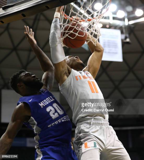 Bruce Brown Jr. #11 of the Miami Hurricanes dunks the ball as he is defended by Giddy Potts of the Middle Tennessee Blue Raiders during the second...