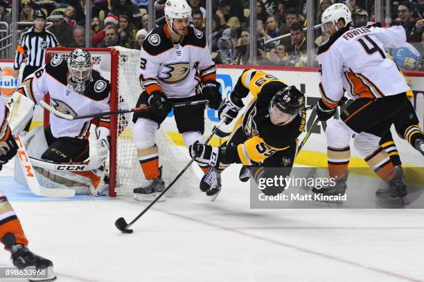 Jake Guentzel of the Pittsburgh Penguins reaches for the puck against the Anaheim Ducks at PPG PAINTS Arena on December 23, 2017 in Pittsburgh,...