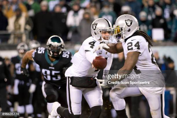 Oakland Raiders QB Derek Carr hands the ball off to Oakland Raiders RB Marshawn Lynch in the first half during the game between the Oakland Raiders...