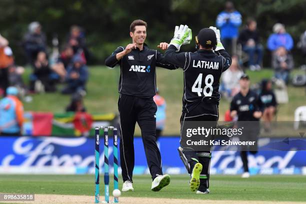 Mitchell Santner of New Zealand is congratulated by Tom Latham of New Zealand after dismissing Rovman Powell of the West Indies during the One Day...