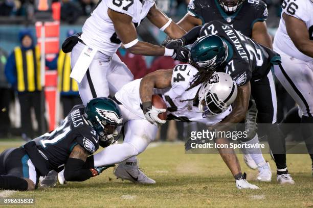 Oakland Raiders RB Marshawn Lynch is tackled by Eagles Safety Malcolm Jenkins and CB Jalen Mills in the first half during the game between the...