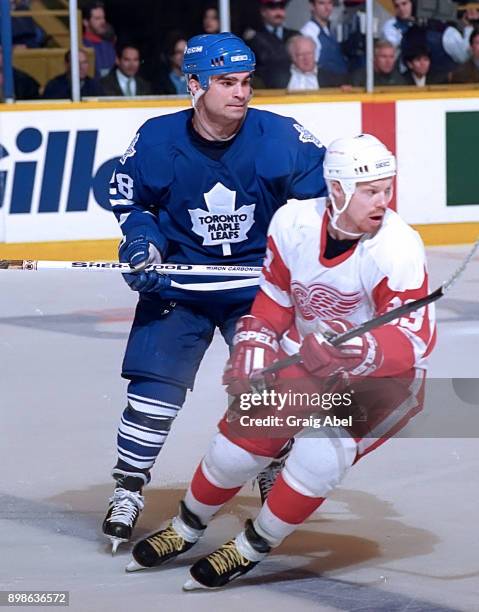 Kris Draper of the Detroit Red Wings skates against Tie Domi of the Toronto Maple Leafs during NHL game action on March 20, 1996 at Maple Leaf...