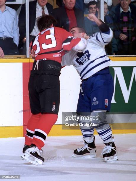 Reid Simpson of the New Jersey Devils battles with Tie Domi of the Toronto Maple Leafs during NHL action on March 6, 1996 at Maple Leaf Gardens in...