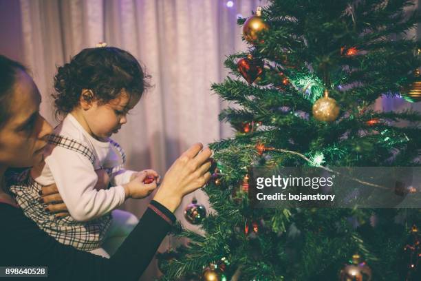 niedliche kleine mädchen und mutter mit christmas tree - mother of all balls stock-fotos und bilder