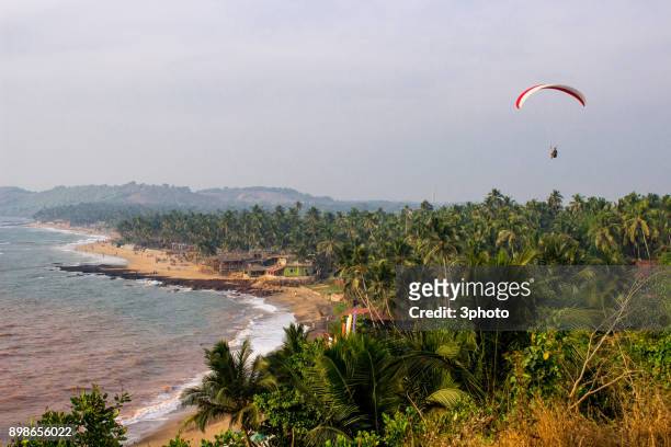 flights on a paraplane over a beach of goa - goa resort stock pictures, royalty-free photos & images