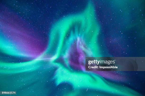 aurora borealis looks like phoenix display directly above the head in iceland - northern light photos et images de collection