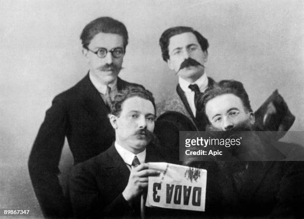Dadaist writers Andre Breton, Rene Hilsum, Louis Aragon and Paul Eluard, costumed, reading Dada 3, 1919