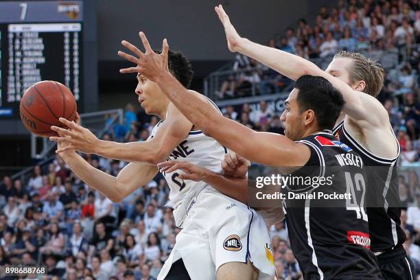 Travis Trice of Brisbane Bullets passes the ball under pressure during the round 12 NBL match between Melbourne United and the Brisbane Bullets at...