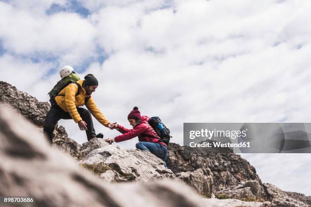 germany, bavaria, oberstdorf, man helping woman climbing up rock - support moving up stock pictures, royalty-free photos & images