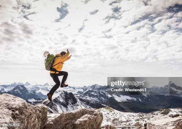 germany, bavaria, oberstdorf, man jumping on rock in alpine scenery - hochgefühl stock-fotos und bilder