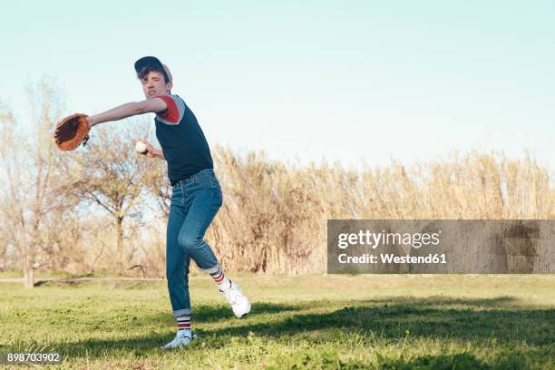 young man playing baseball in park - throwing baseball stock pictures, royalty-free photos & images