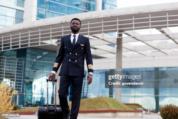 piloto de avião de bluck puxando sua lagguge aeroporto terminal - pilota - fotografias e filmes do acervo