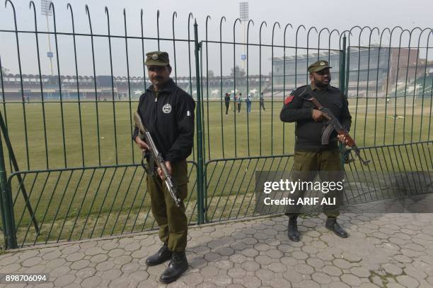 Pakistani policemen stand guard during the national cricket team's practice at the Qaddafi Stadium in Lahore on December 26, 2017. Pakistan still...